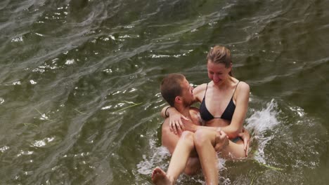 Caucasian-couple-having-a-good-time-on-a-trip-to-the-mountains,-wearing-bathing-suits-and-standing-i