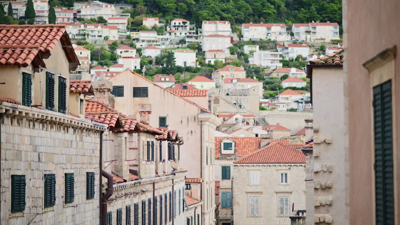 Rua histórica na Cidade Velha de Dubrovnik com edifícios tradicionais de pedra e janelas com venezianas