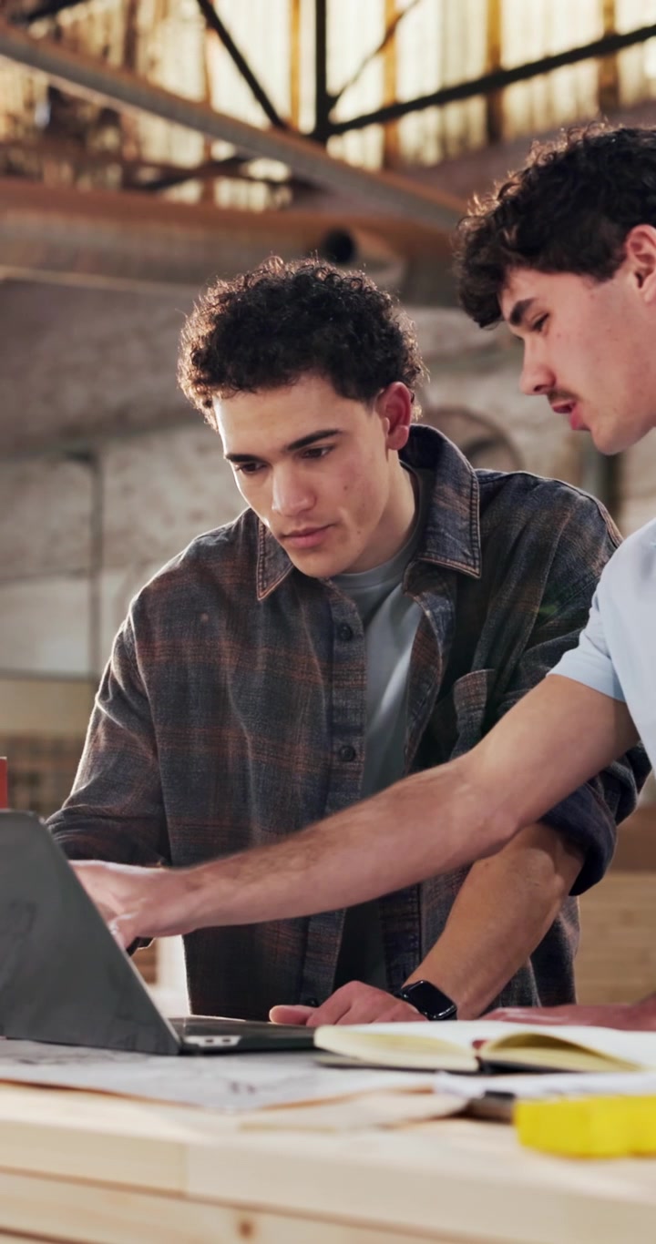 Due giovani uomini che collaborano a un progetto usando un laptop