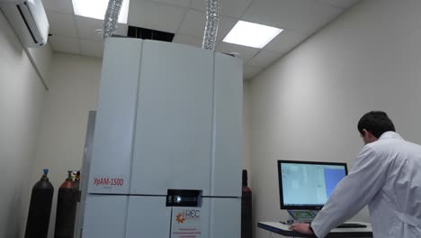 scientist operating a ypam-150d spectroscopy machine in a research laboratory