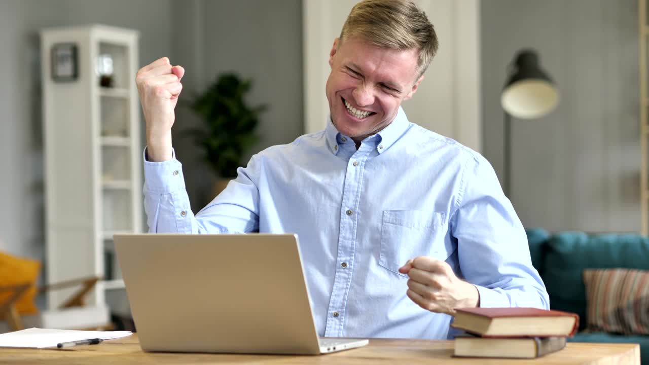 un hombre de negocios emocionado celebrando el éxito en el trabajo.
