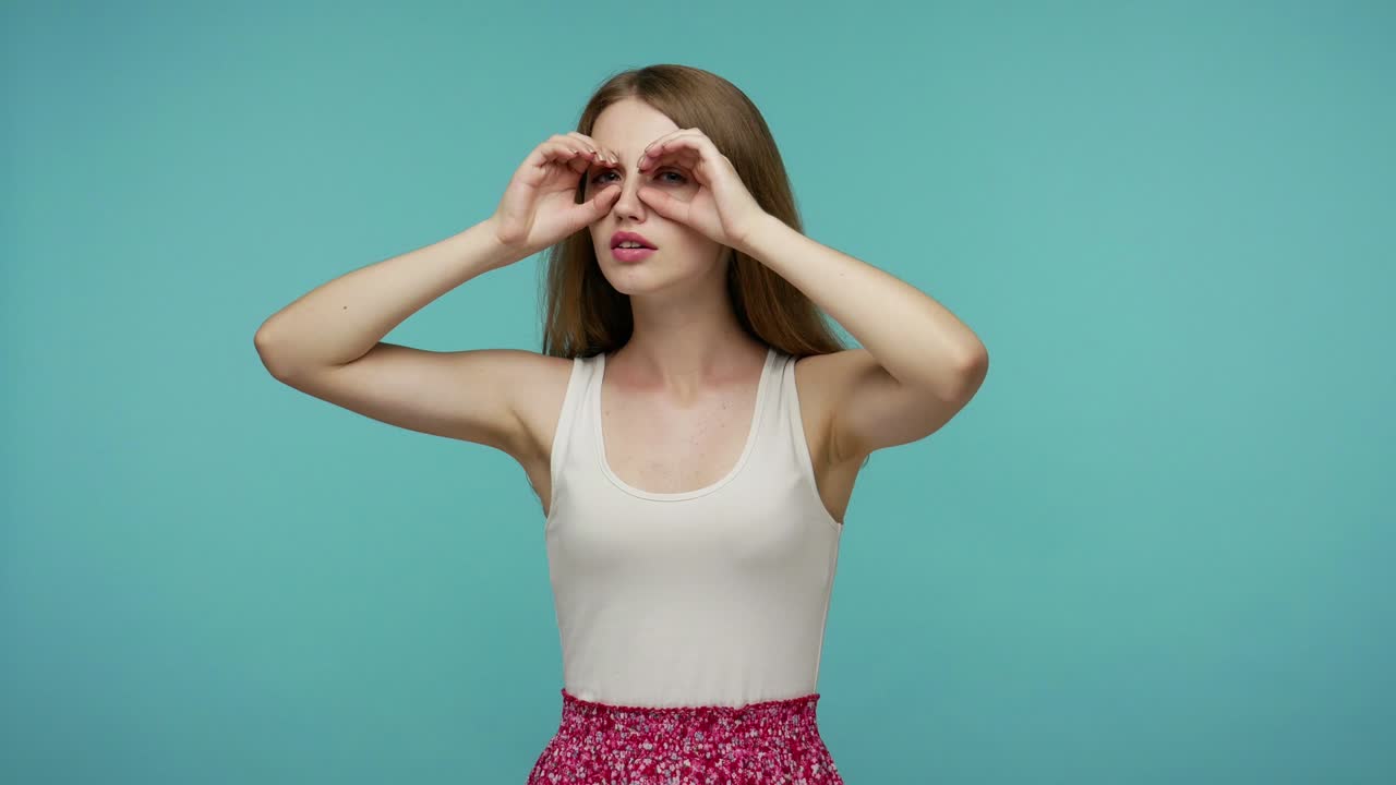 retrato de una chica curiosa observando el horizonte, mirando a lo lejos a través de binoculares, gestos de la mano, buscando