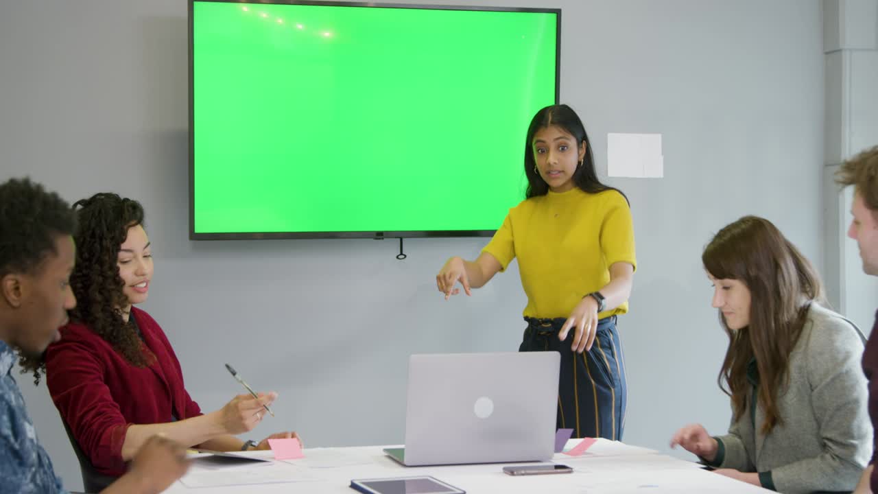 mujer líder en reuniones con colegas con televisión de pantalla verde