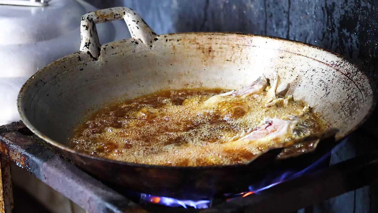 Cucinare carne in una padella su una fiamma aperta