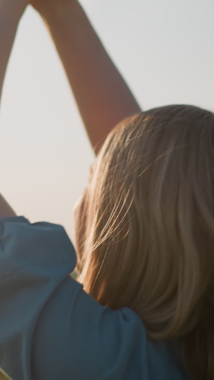 파란 드레스를 입은 여성의 클로즈업, 그녀의 손은 기게 올려, 그녀의 얼굴에 미소와 함께 회전, 거품이 배경에 떠, 순수한 행복과 무모한 기의 순간을 포착.