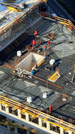 roof framework being built. workers lay rebar and insulation on a rooftop during the day to ensure the building's integrity