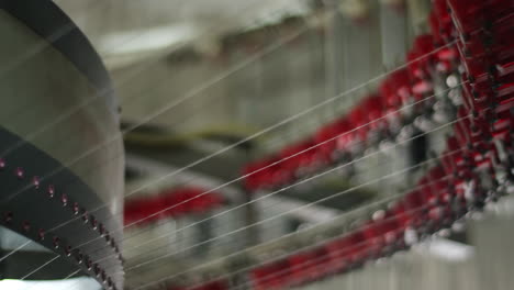 los hilos de algodón viajan a través de los engranajes de una maquinaria de tejido de algodón automatizada en una fábrica textil en china