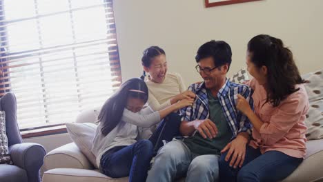 family having fun together on sofa in living room 4k