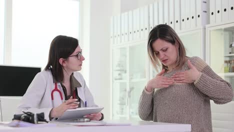 woman describes chest pain to doctor during medical consultation