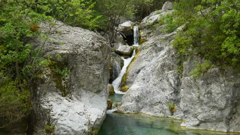 Tilt-up-slow-motion-shot-of-strong-stream-waterfall-Enipeas-River-Gorge-Mountain-Olympus-Greece