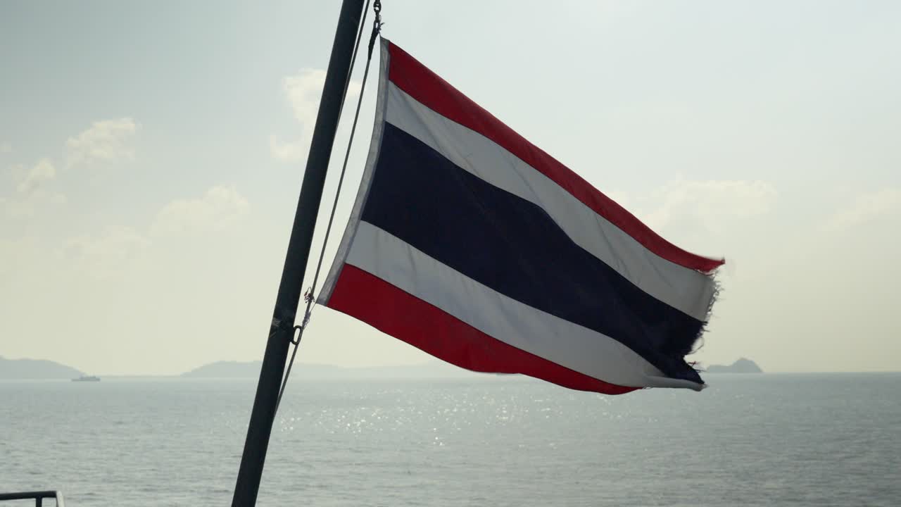 Slowmotion shot of a Thailand flag blowing in the wind on a ferry whilst sailing