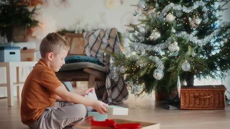 el niño abre el regalo y está feliz durante la navidad.