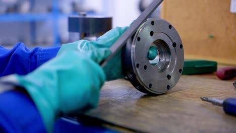 a man with a file processes a metal element