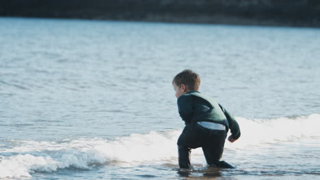 Gruppe-Von-Kindern,-Die-Im-Herbstlichen-Strandurlaub-In-Wellen-Spielen