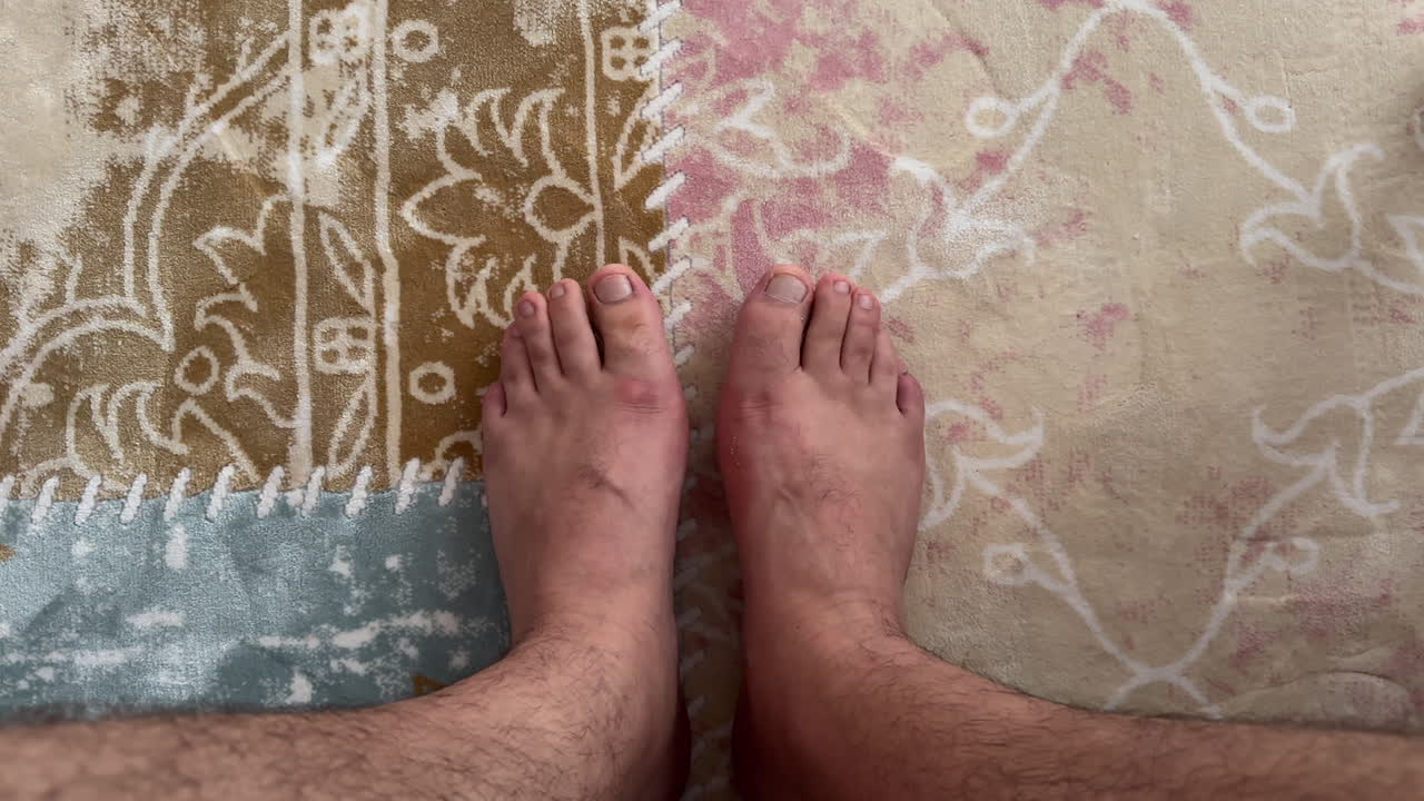 Close-up of bare feet resting on a multicolored patterned carpet, showing home comfort and relaxed indoor atmosphere
