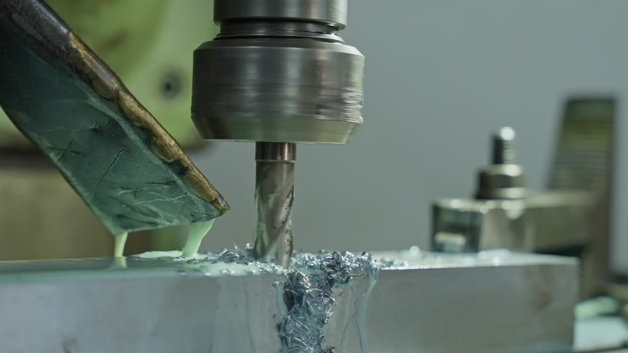 close up of lathe cutting metal with coolant and sharp rotating bit