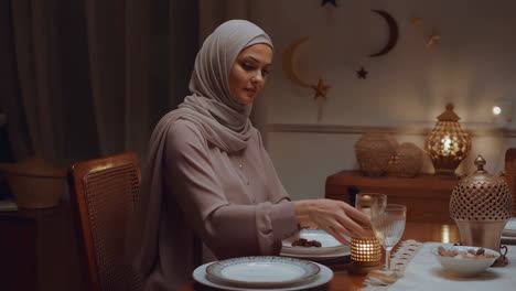 muslim woman at iftar table with dates during ramadan