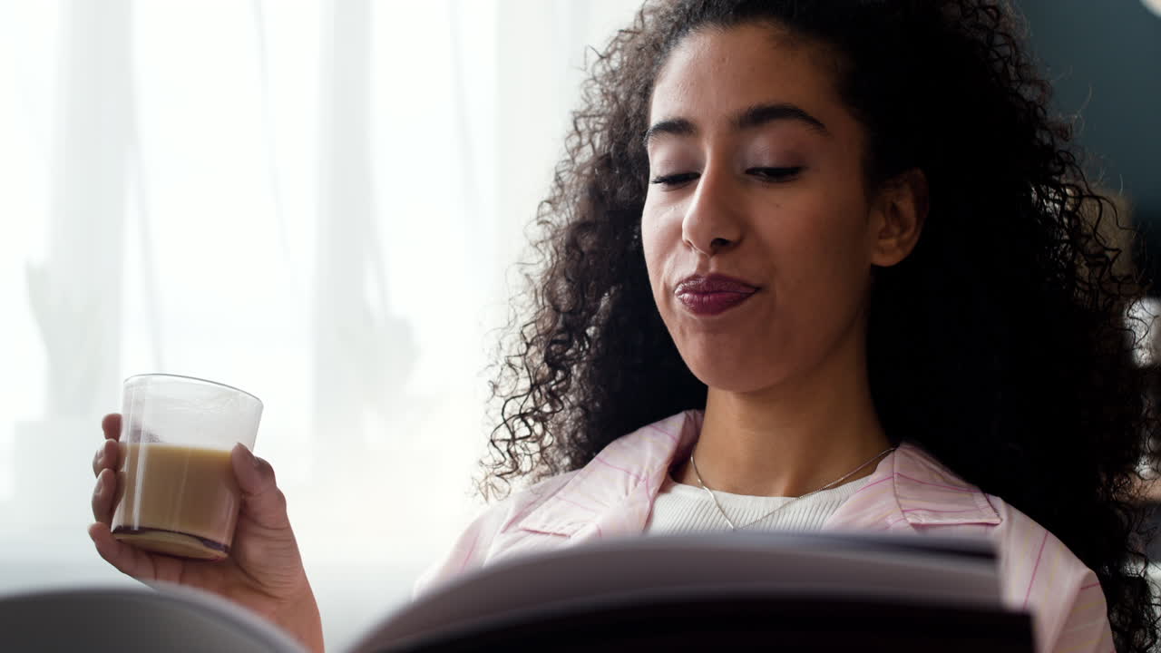Woman enjoys reading and a warm beverage at home