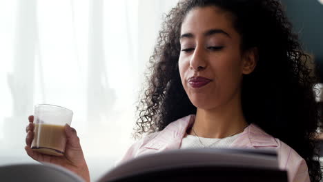 woman enjoys reading and a warm beverage at home