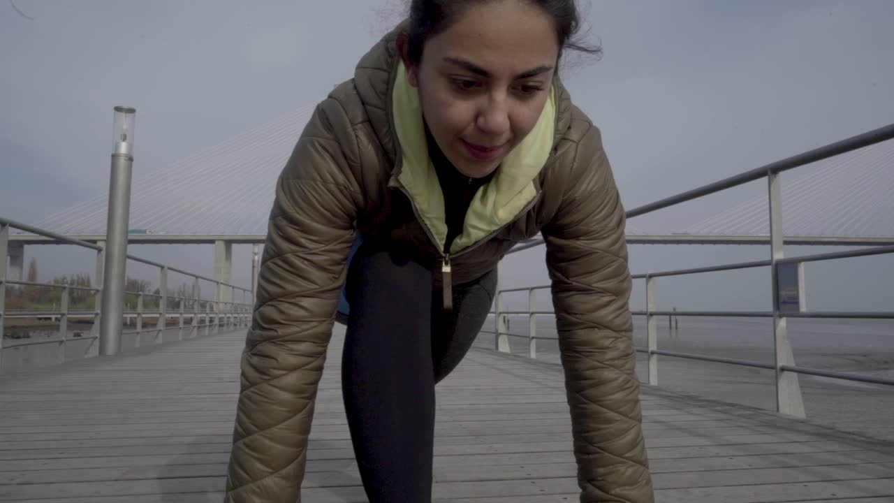 Cheerful hindu woman on start line ready to run