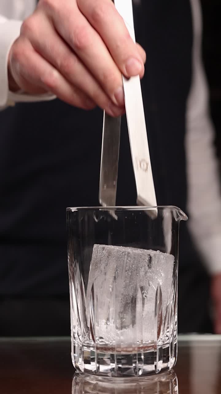 테일 컵 에 얼음 을 넣는 바텐더