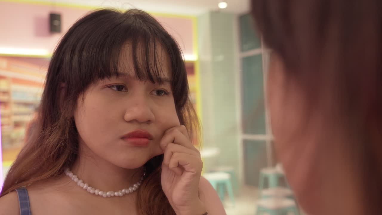 Young Asian girl reflects unhappily, facial features, skin complexion