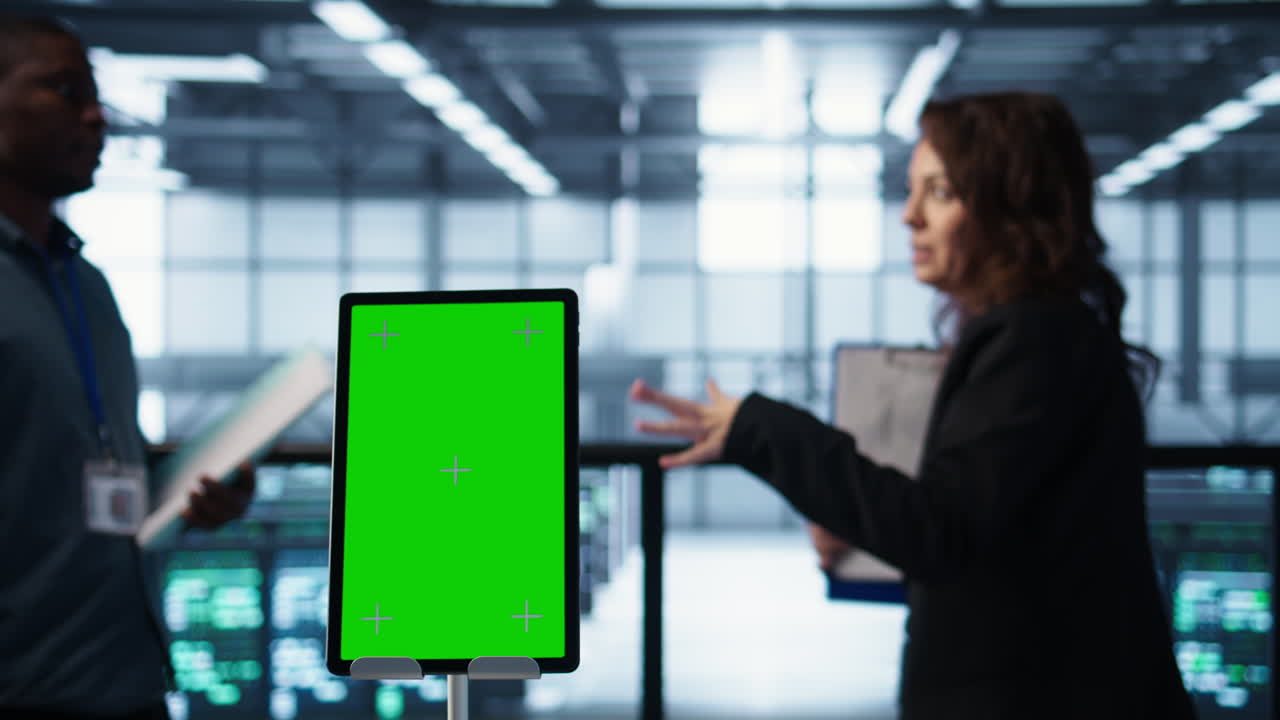데이터 센터를 조사하는 동료들 에 있는 크로마 키 태블릿의 클로즈업