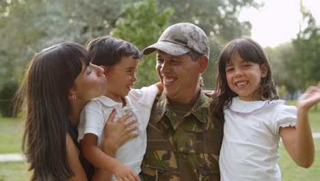 Happy-family-couple-and-two-kids-waving-hello-at-camera