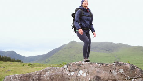 fit woman reaching the summit and looking around