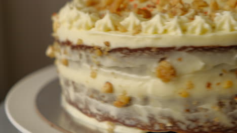 close up of rotating carrot walnut cake covered in cream