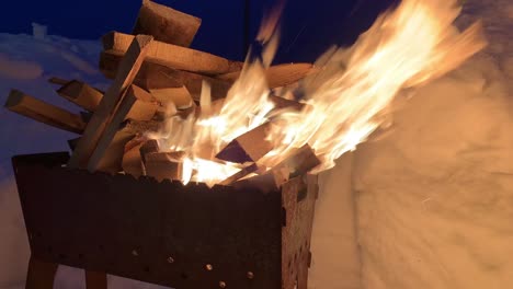 la leña apilada en la parrilla arde bien y brillantemente por la noche.