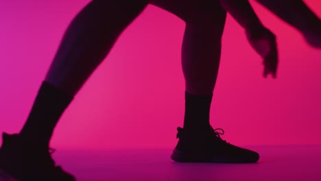 Close-Up-Studio-Portrait-Of-Male-Basketball-Player-Dribbling-And-Bouncing-Ball-Against-Pink-Lit-Background-6