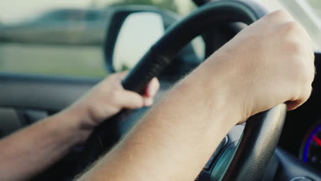 the hands of the male driver on the steering wheel of the car hd video