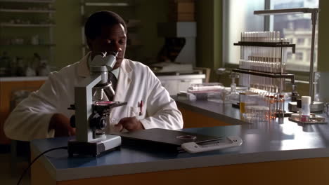 scientist examining sample under microscope in laboratory