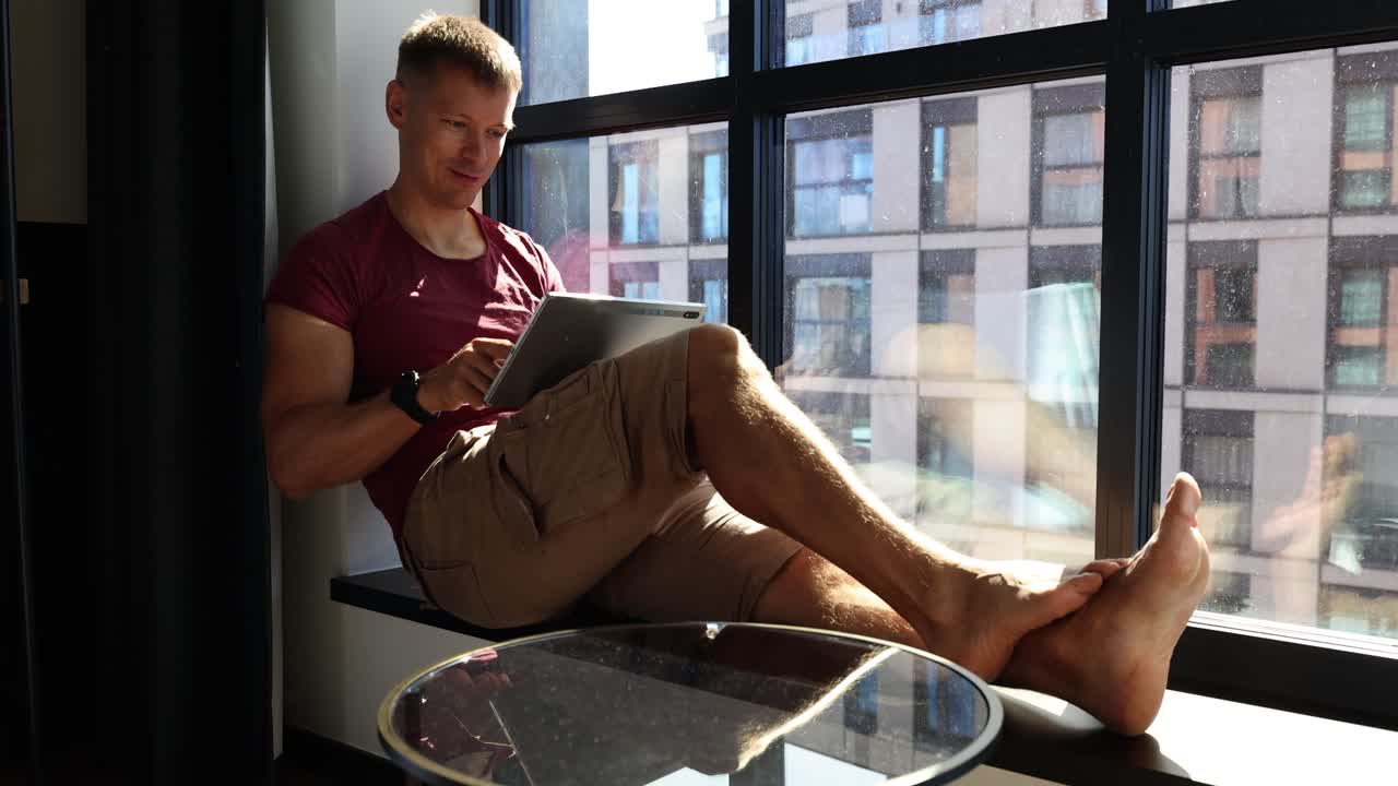 Man using tablet by the window