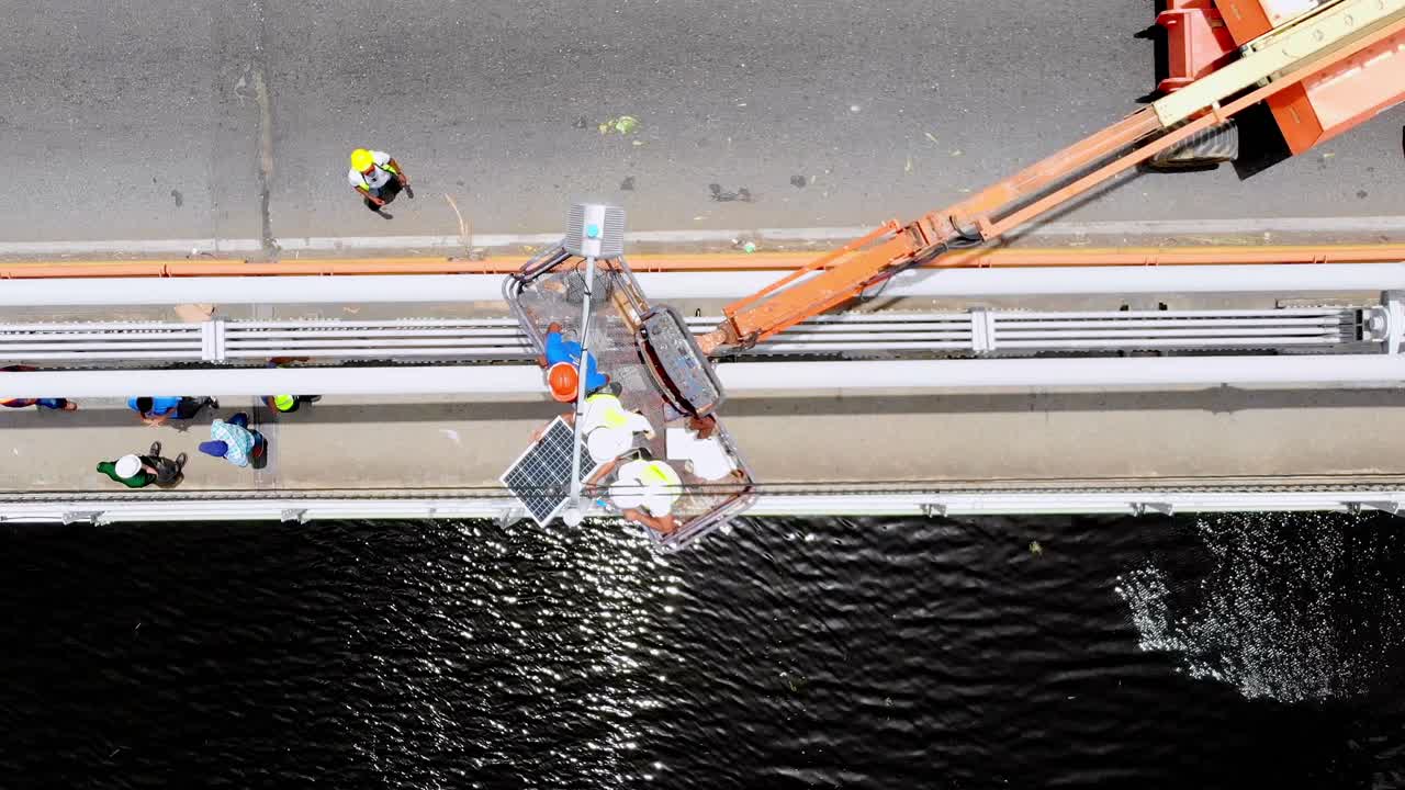 태양광 패널을 설치하는 다리 위의 노동자 팀