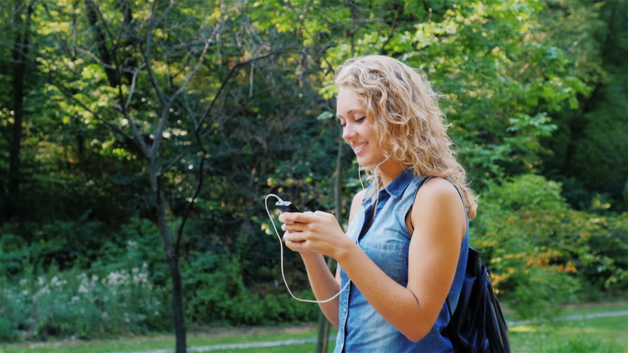 A young attractive woman walks in a well-groomed park on a summer day 7