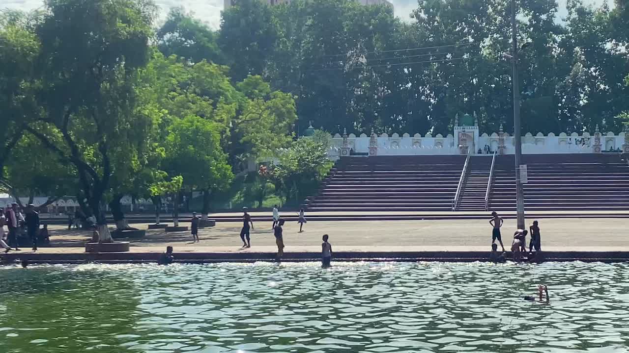 niños jugando y bañándose en una piscina pública para el calor del verano