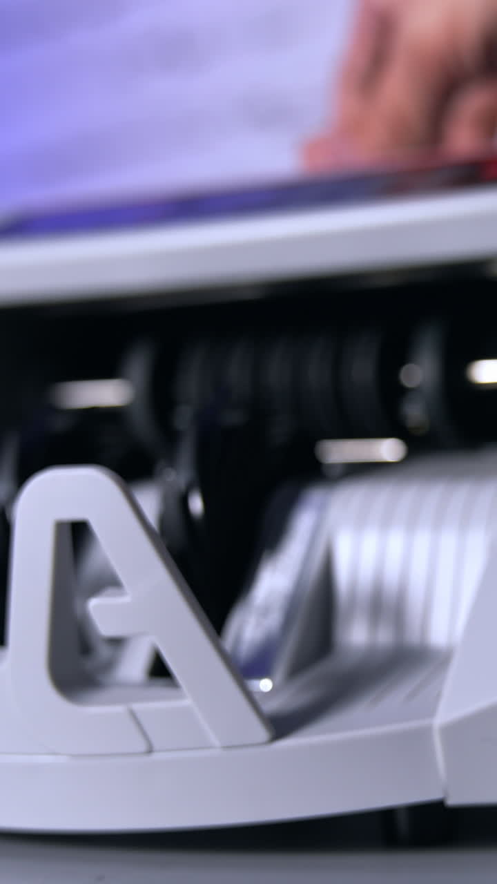 Person putting money at the banking modern counter. Special machine for counting banknotes. Money and business concept. Cropped view. Vertical video