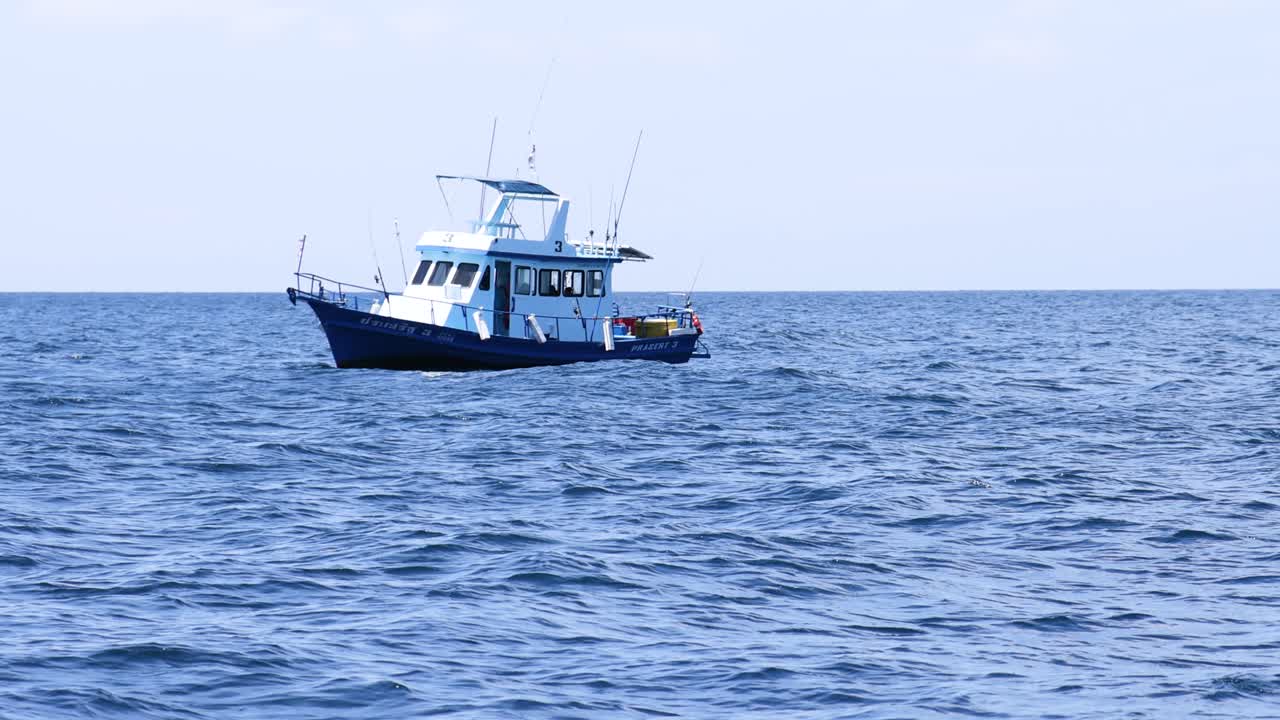A boat navigates calm seas near Phuket, Thailand, under clear skies, showcasing serene maritime travel
