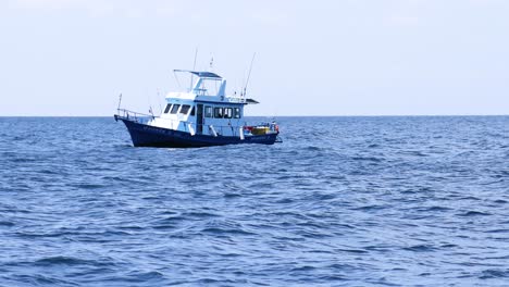 a boat navigates calm seas near phuket, thailand, under clear skies, showcasing serene maritime travel