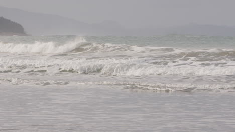 pan shot over perfect castle point waves at the beach in new zealand