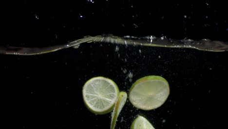 rebanadas de cal que caen en el agua con burbujas de aire.