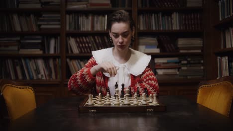 woman playing chess in a library