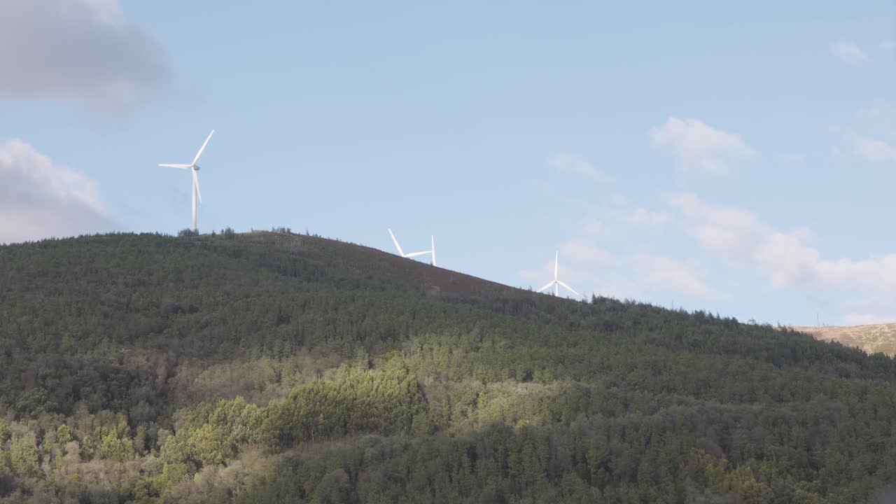 Large windmills spinning slowly on a clear day