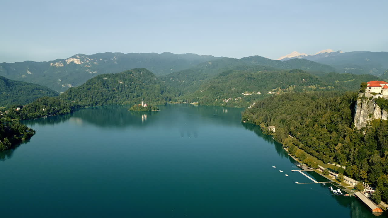 Acque serene sul lago di Bled che riflettono il cielo blu e le montagne, Slovenia, ripresa con drone
