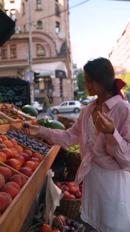 woman shopping for fruit at an outdoor market