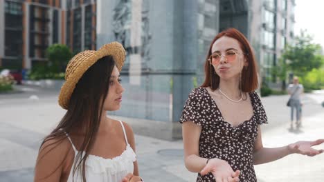 dos mujeres jóvenes en conversación al aire libre
