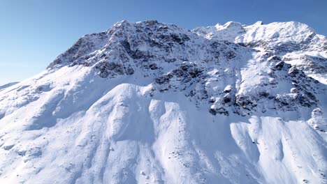 vista aérea del paisaje montañoso cubierto de nieve con bosques en un soleado día de invierno en alp grum, suiza