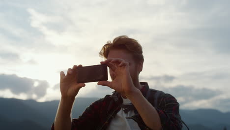 happy blogger take photo on smartphone close up. tourist photographing mountains